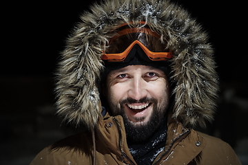 Image showing man at winter in stormy weather night wearing warm fur jacket