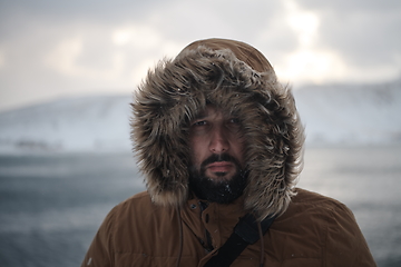 Image showing man at winter in stormy weather wearing warm fur jacket