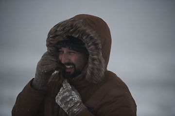 Image showing man at winter in stormy weather wearing warm fur jacket