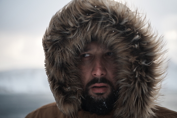 Image showing man at winter in stormy weather wearing warm fur jacket