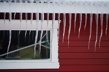 Image showing icicles on the roof of a red house in Norway