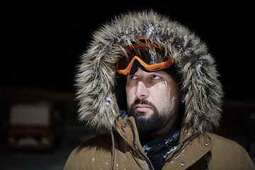 Image showing man at winter in stormy weather night wearing warm fur jacket