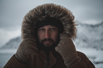 Image showing man at winter in stormy weather wearing warm fur jacket