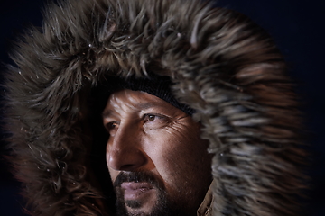 Image showing man at winter in stormy weather night wearing warm fur jacket