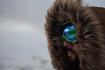 Image showing man at winter in stormy weather wearing warm fur jacket