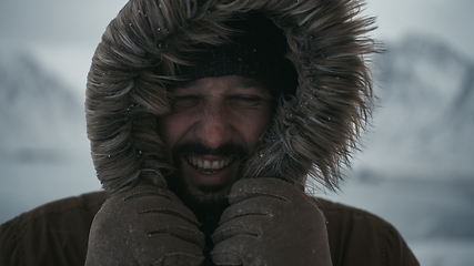 Image showing man at winter in stormy weather wearing warm fur jacket