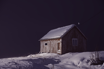 Image showing Traditional Norwegian fisherman\'s cabins covered with snow at night