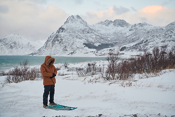 Image showing Muslim traveler praying in cold snowy winter day