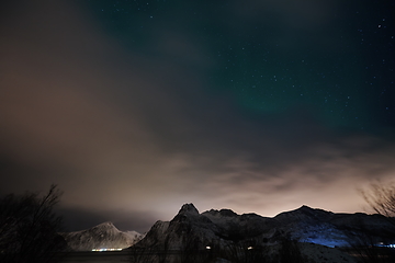 Image showing Aurora borealis Green northern lights above mountains