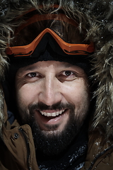 Image showing man at winter in stormy weather night wearing warm fur jacket