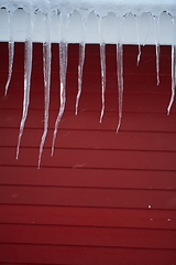 Image showing icicles on the roof of a red house in Norway