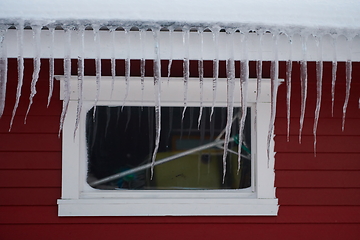 Image showing icicles on the roof of a red house in Norway