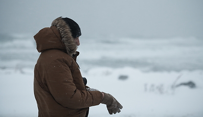 Image showing man at winter in stormy weather wearing warm fur jacket