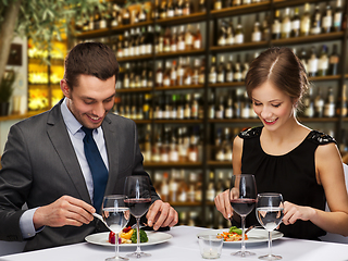 Image showing smiling couple eating main course at restaurant