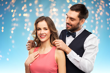 Image showing happy man puts necklace on his girlfriend