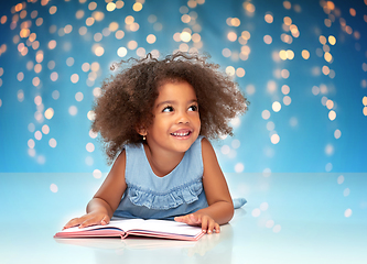 Image showing smiling little african american girl reading book