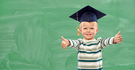 Image showing happy little boy in mortar board showing thumbs up