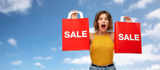 Image showing surprised young woman with shopping bags on sale