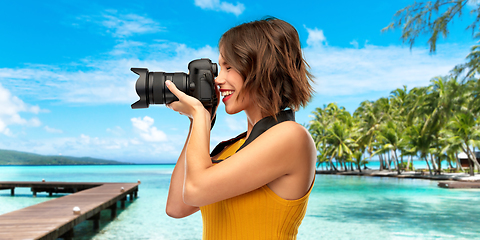 Image showing happy woman photographer with camera on beach