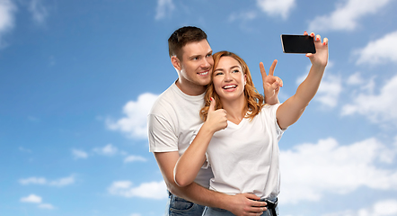 Image showing happy couple in white t-shirts taking selfie