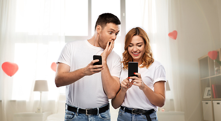 Image showing happy couple with smartphones on valentines day