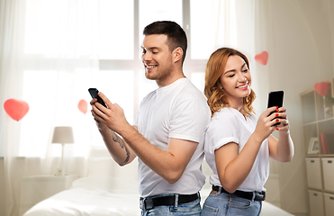 Image showing happy couple with smartphones on valentines day