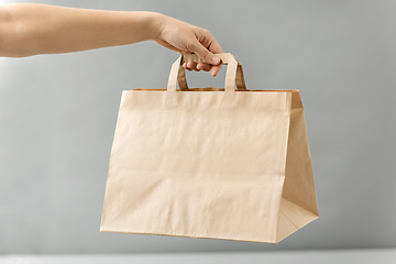 Image showing hand holding takeaway food in paper bag with lunch