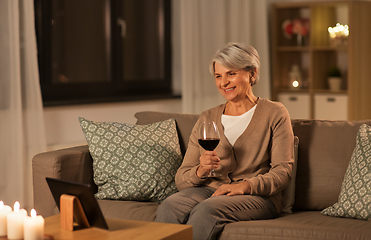 Image showing senior woman with tablet pc drinking wine at home