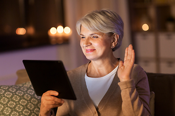 Image showing happy senior woman with tablet pc at home at night