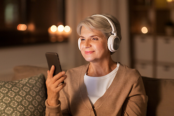 Image showing senior woman in headphones listening to music