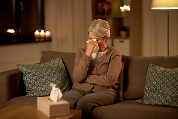 Image showing crying senior woman wiping tears with paper tissue