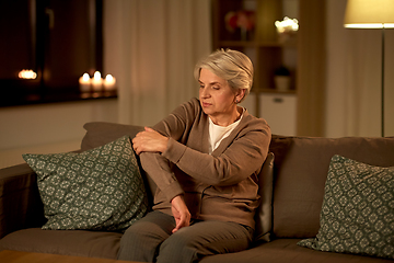 Image showing senior woman suffering from pain in hand at home