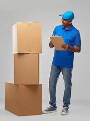 Image showing indian delivery man with boxes and clipboard