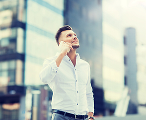 Image showing happy man with smartphone calling on city street