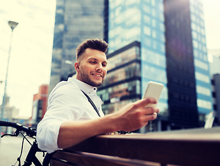 Image showing happy man with smartphone and bicycle in city