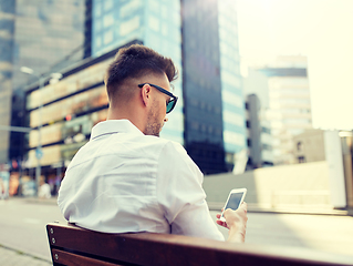 Image showing close up of man texting on smartphone in city