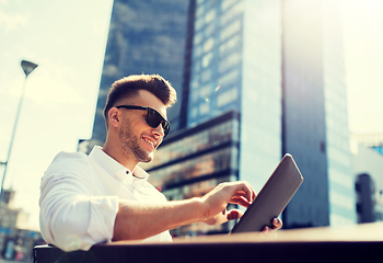 Image showing man with tablet pc sitting on city street bench