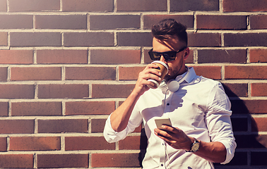 Image showing man with smartphone and coffee cup on city street