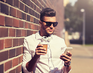 Image showing man with smartphone and coffee cup on city street