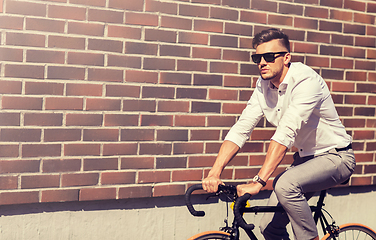 Image showing young man riding bicycle on city street