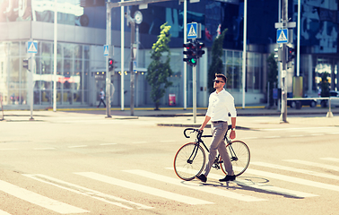 Image showing young man with bicycle on crosswalk in city