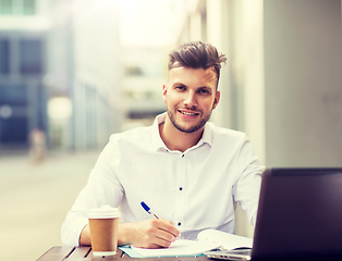 Image showing man with laptop and coffee at city cafe