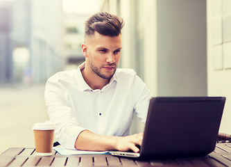 Image showing man with laptop and coffee at city cafe