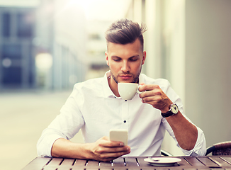 Image showing man with smartphone drinking coffee at city cafe