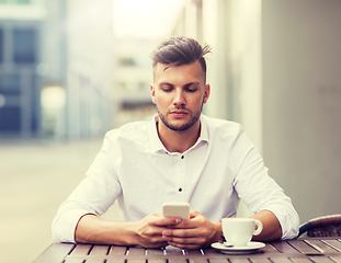 Image showing man with smartphone and coffee at city cafe