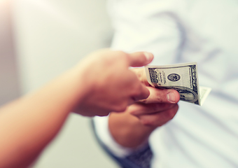 Image showing close up of hands giving and receiving dollar money