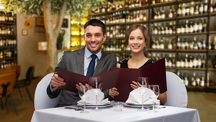 Image showing smiling couple with menus at restaurant