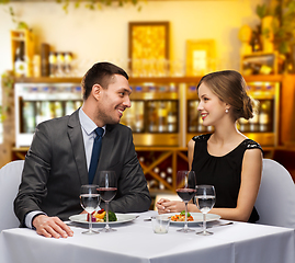 Image showing smiling couple with food and wine at restaurant