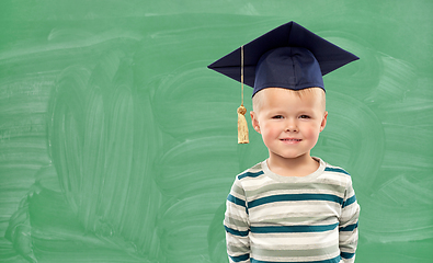 Image showing little boy in mortar board over green chalkboard