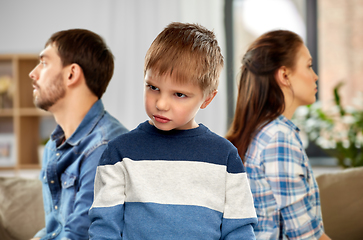 Image showing sad little boy with unhappy parents at home